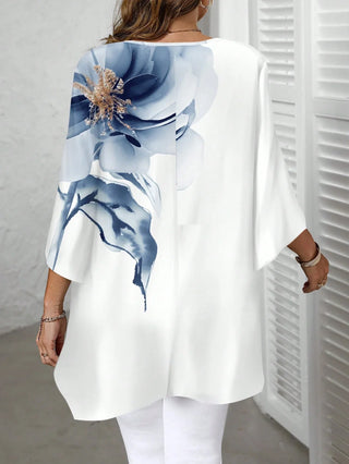 Blusa amplia con escote redondo, mangas 3/4 y dobladillo asimétrico, con estampado floral, disponible en tallas cómodas, adecuada para vacaciones